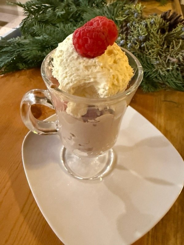 Dessert drink topped with whipped cream and a raspberry