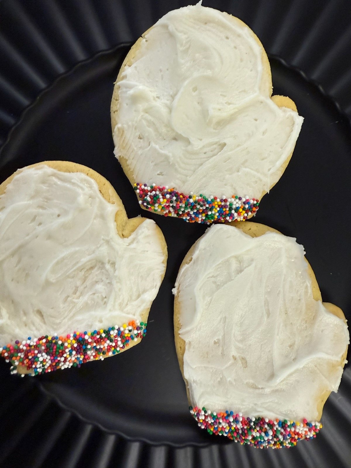 Heart-shaped frosted cookies with sprinkles